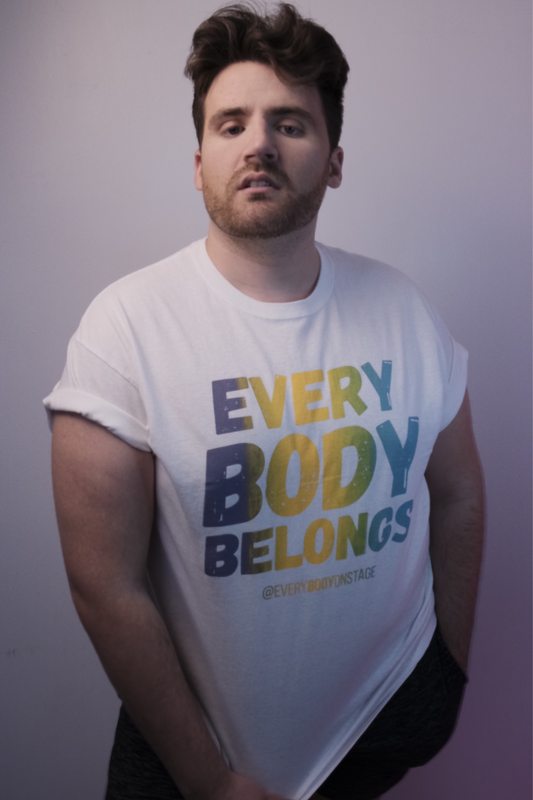 A white t-shirt that reads Every Body Belongs modelled by EveryBODY on Stage Founder Greg Carruthers